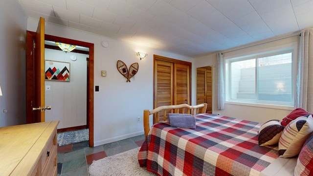 bedroom with a closet and baseboards