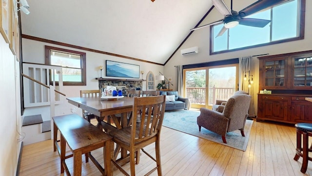 dining room featuring ceiling fan, light wood-type flooring, high vaulted ceiling, an AC wall unit, and stairs