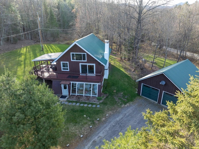 view of front of property with metal roof, a chimney, a front yard, dirt driveway, and an outdoor structure