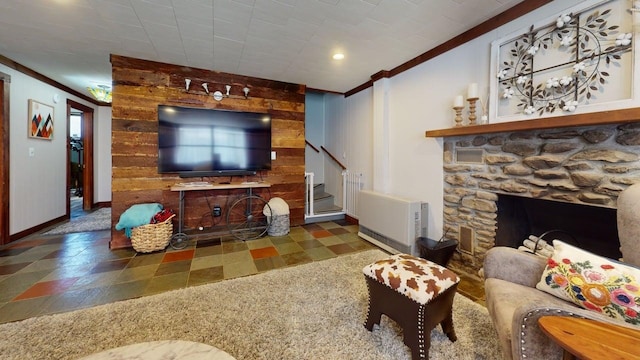 living area with crown molding, visible vents, a fireplace, baseboards, and stairway