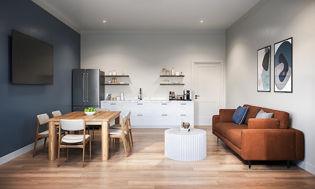 dining area featuring indoor wet bar, baseboards, ornamental molding, and light wood-style floors