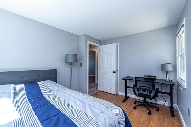 bedroom with baseboards and wood finished floors