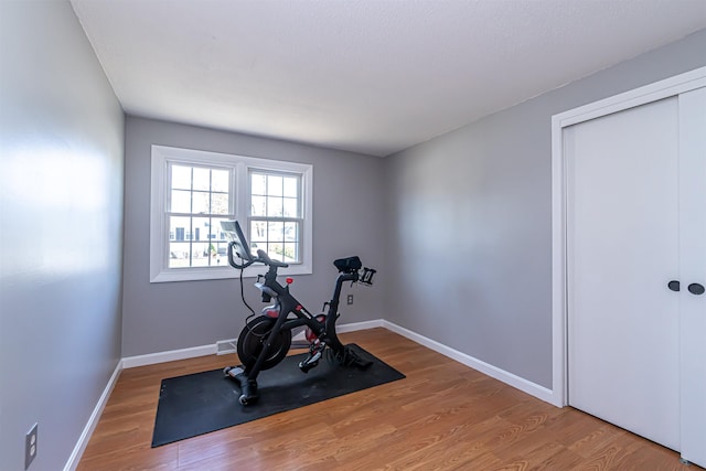 workout room with baseboards and wood finished floors