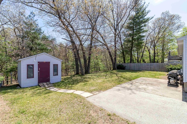view of yard featuring a patio, a fenced backyard, and an outdoor structure
