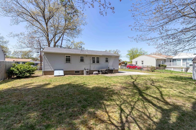 rear view of house featuring a yard and fence