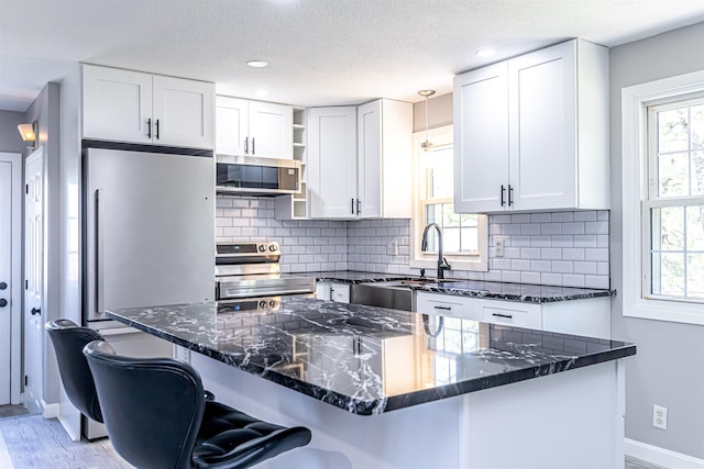 kitchen featuring a sink, baseboards, open shelves, and stainless steel appliances