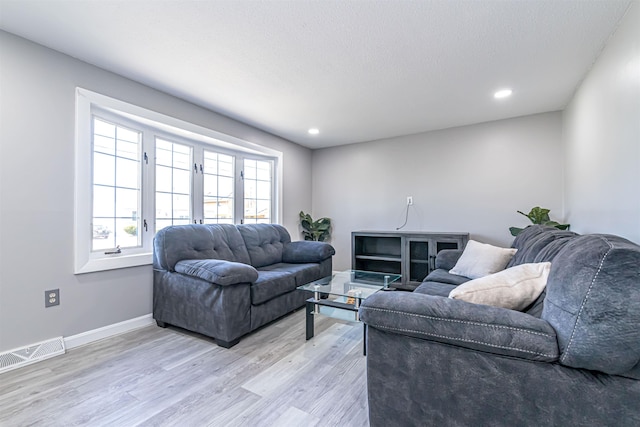 living area with visible vents, recessed lighting, light wood finished floors, and baseboards