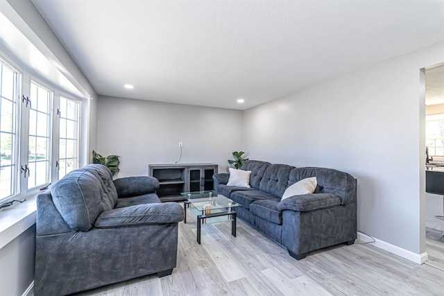 living area with recessed lighting, baseboards, and light wood finished floors
