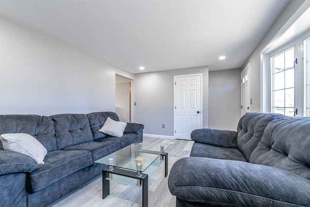 living room with recessed lighting, baseboards, and light wood finished floors