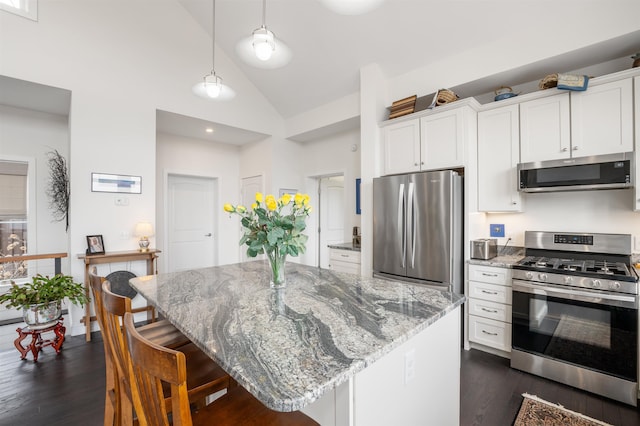 kitchen with stainless steel appliances, light stone countertops, dark wood-style floors, and white cabinetry