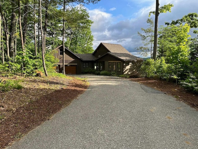 rustic home with a garage and aphalt driveway