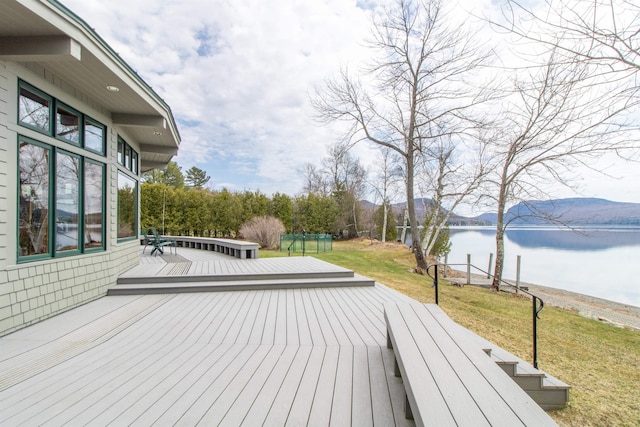 deck with a lawn and a water view