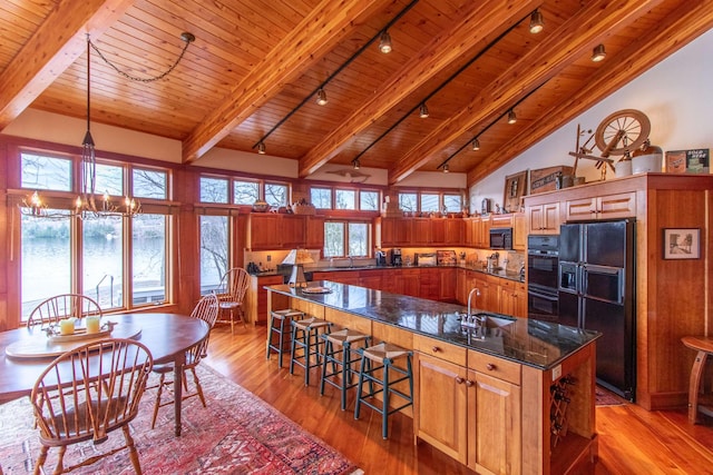 kitchen featuring wood ceiling, brown cabinetry, black appliances, and rail lighting