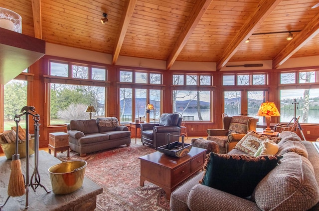 living room featuring a healthy amount of sunlight, wood ceiling, beamed ceiling, and a water view