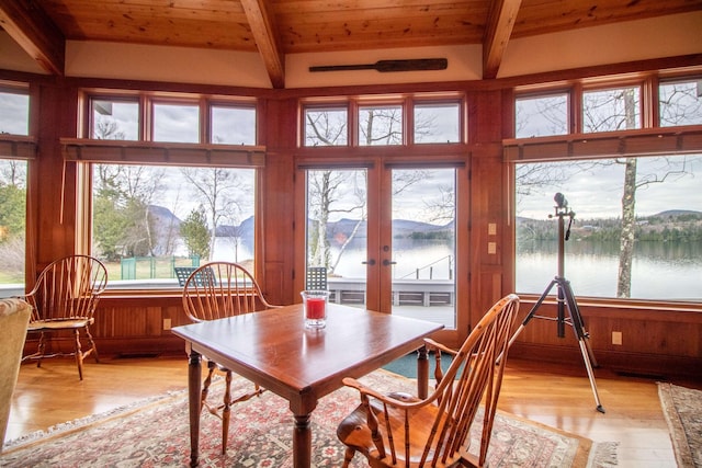 dining area with a healthy amount of sunlight, beamed ceiling, and light wood-type flooring