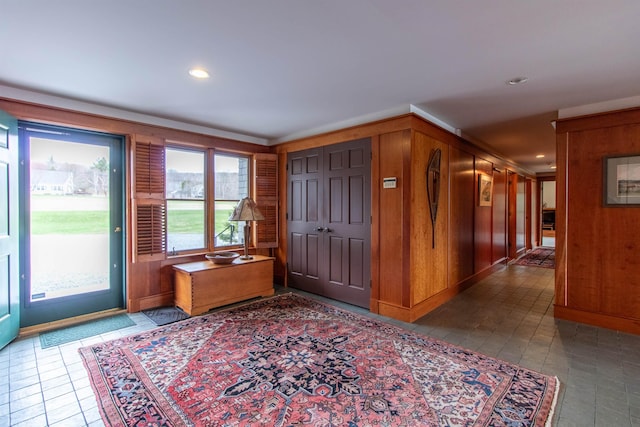 entrance foyer featuring wooden walls and recessed lighting