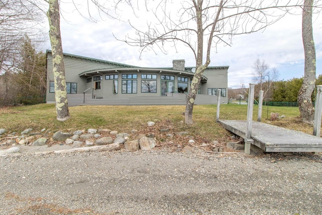 back of property with a lawn and a chimney
