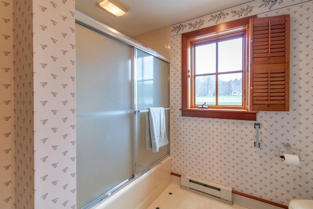 bathroom with baseboards, a baseboard radiator, shower / bath combination with glass door, and wallpapered walls
