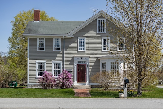 view of front of property with a front lawn and a chimney