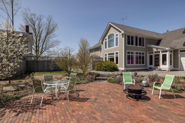 view of patio / terrace with fence, entry steps, and an outdoor fire pit