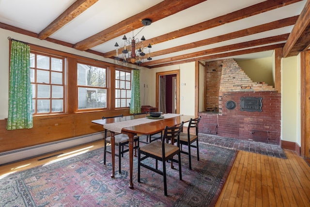 dining area featuring a chandelier, beam ceiling, hardwood / wood-style flooring, and a baseboard radiator