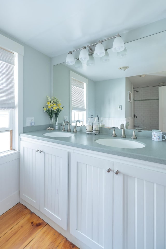 bathroom with a sink, walk in shower, and a wealth of natural light