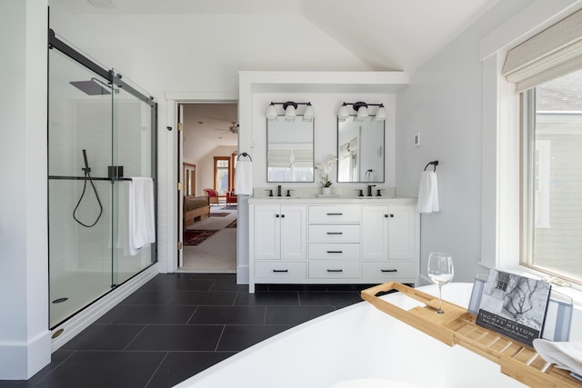 ensuite bathroom featuring tile patterned flooring, vaulted ceiling, and a shower stall
