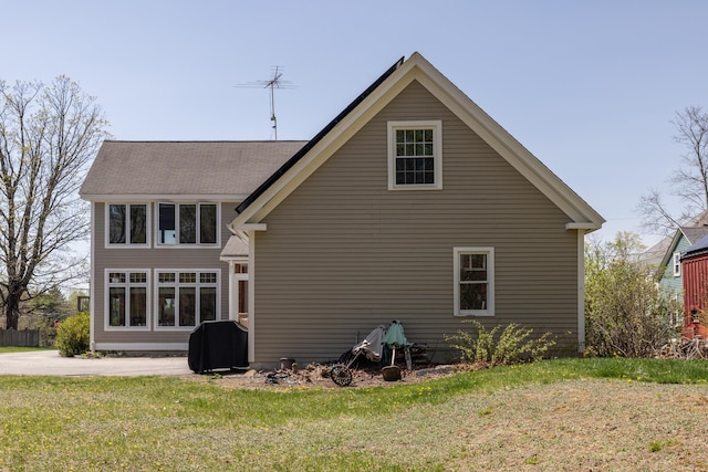 rear view of property featuring a yard