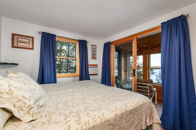 bedroom with wood finished floors and access to exterior