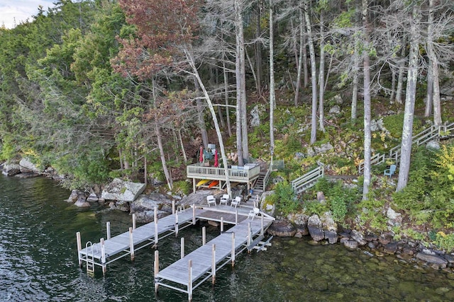 view of dock featuring stairway and a deck with water view