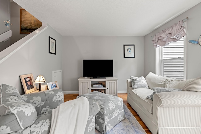 living area with baseboards and wood finished floors