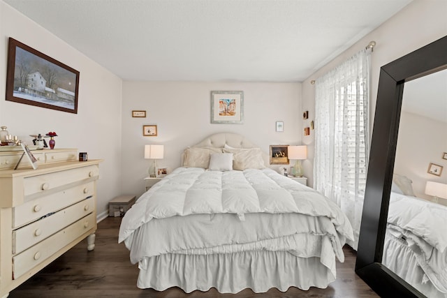 bedroom with baseboards and dark wood-style flooring