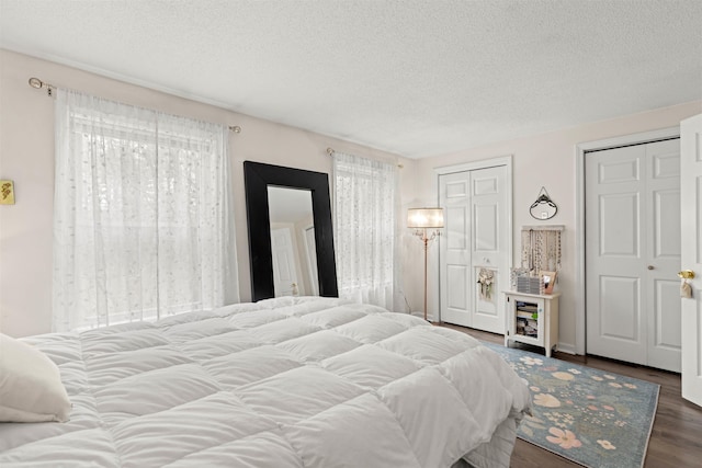 bedroom with a textured ceiling and wood finished floors