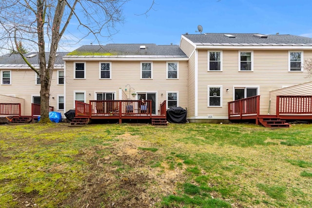 back of house with a lawn and a wooden deck