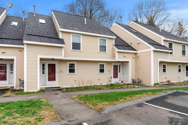 townhome / multi-family property with a shingled roof, uncovered parking, metal roof, and a standing seam roof