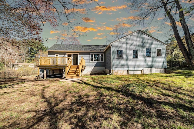 back of property featuring a lawn and a wooden deck
