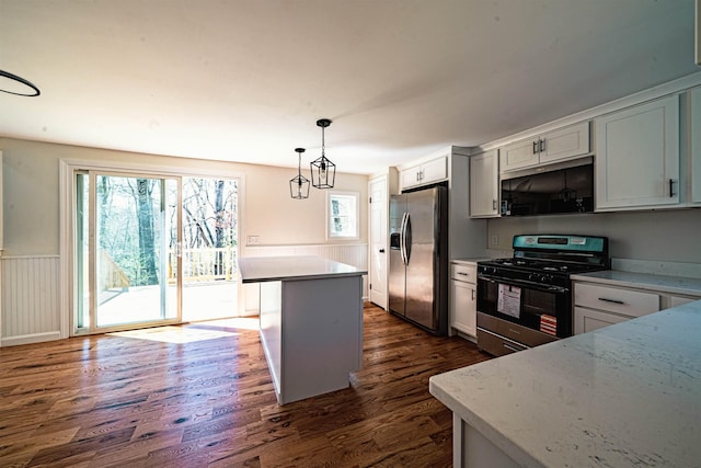 kitchen with dark wood finished floors, a healthy amount of sunlight, gas stove, and stainless steel fridge with ice dispenser