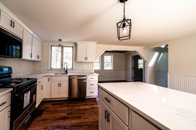 kitchen with dark wood finished floors, black appliances, decorative light fixtures, and white cabinetry