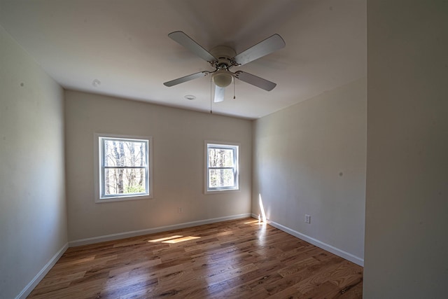 unfurnished room with baseboards, ceiling fan, and wood finished floors