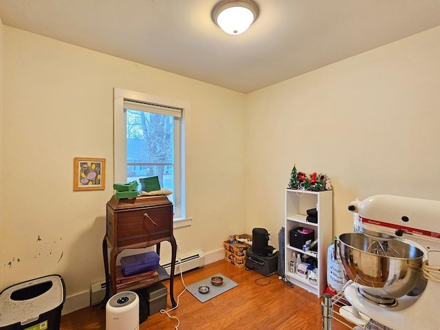 interior space with baseboards, baseboard heating, and wood finished floors