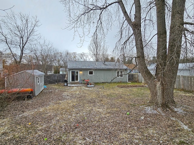 rear view of property featuring a fenced backyard and an outbuilding