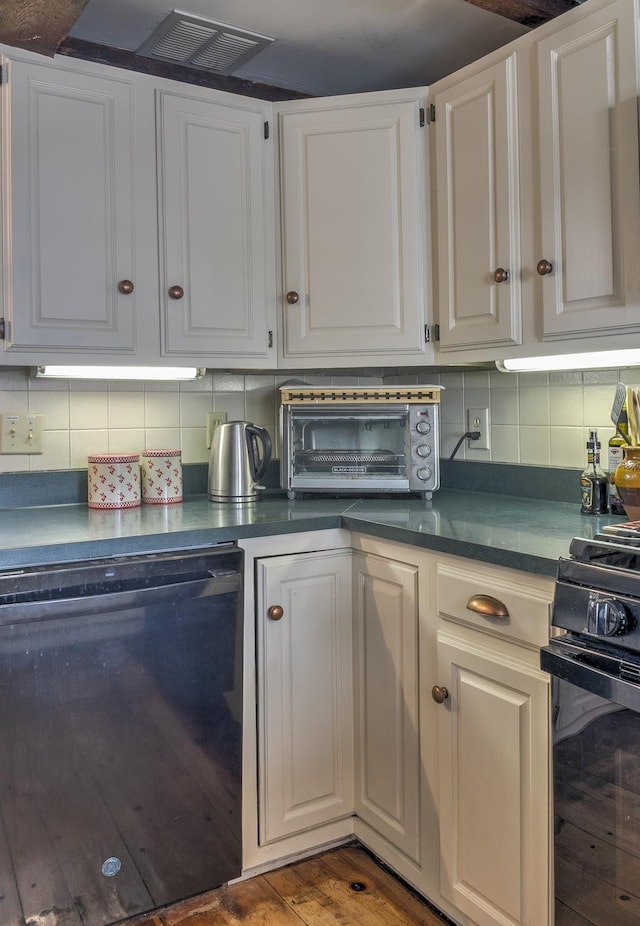kitchen with dark countertops, tasteful backsplash, stove, a toaster, and dishwashing machine