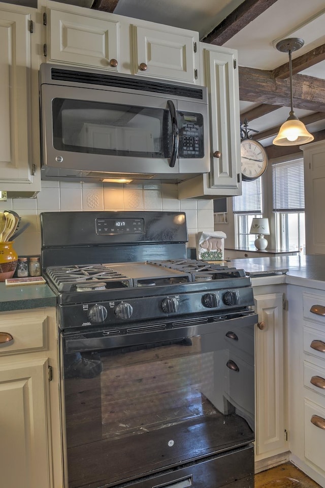 kitchen featuring backsplash, pendant lighting, black gas stove, white cabinets, and stainless steel microwave