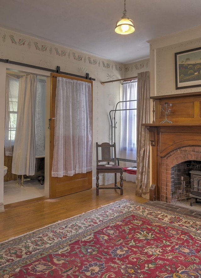 sitting room with wood finished floors and wallpapered walls