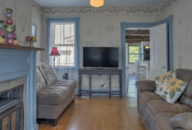 living room with a fireplace and wallpapered walls