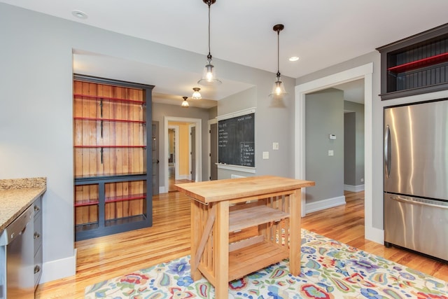 kitchen featuring open shelves, baseboards, light wood finished floors, hanging light fixtures, and stainless steel appliances