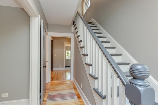 staircase with baseboards and wood finished floors