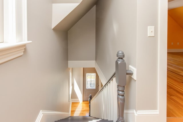 staircase featuring baseboards and wood finished floors