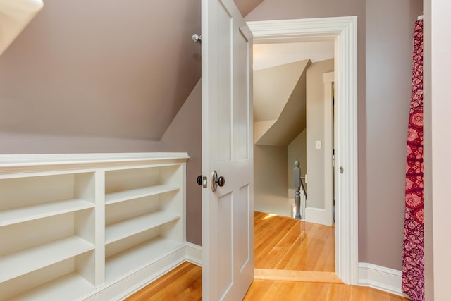 hallway featuring light wood-style floors and lofted ceiling