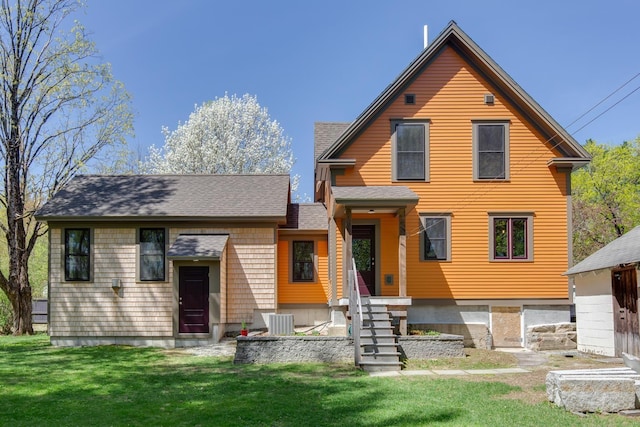rear view of property with roof with shingles, a yard, and cooling unit